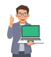 Young businessman with glasses holding laptop with blank screen for copy space showing thumb up vector
