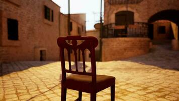 A red chair sitting in the middle of a cobblestone street video