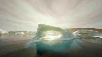 un' grande iceberg galleggiante nel il mezzo di un' corpo di acqua video