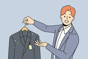 Man holds new jacket with tag offering to buy business clothes for managers or clerks. Guy works as salesman or dry cleaning employee and looks at screen with smile, giving client jacket on hanger vector