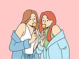 Two women with chupa chups in hands dressed in fashionable seductive clothes eat lollipops. Lovely girls in stylish jackets slung off shoulders to advertise new candies for teenagers vector