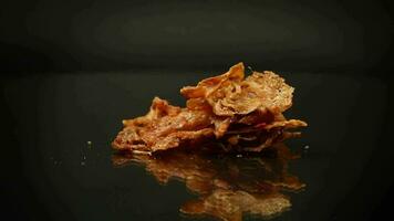 handful of dried meat marinated with spices, isolated on a black background. video