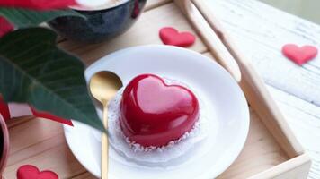 san valentino giorno. cuore sagomato smaltato San Valentino torta e caffè nel di legno vassoio video