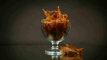 dried meat with spices in a glass bowl, isolated on black background video