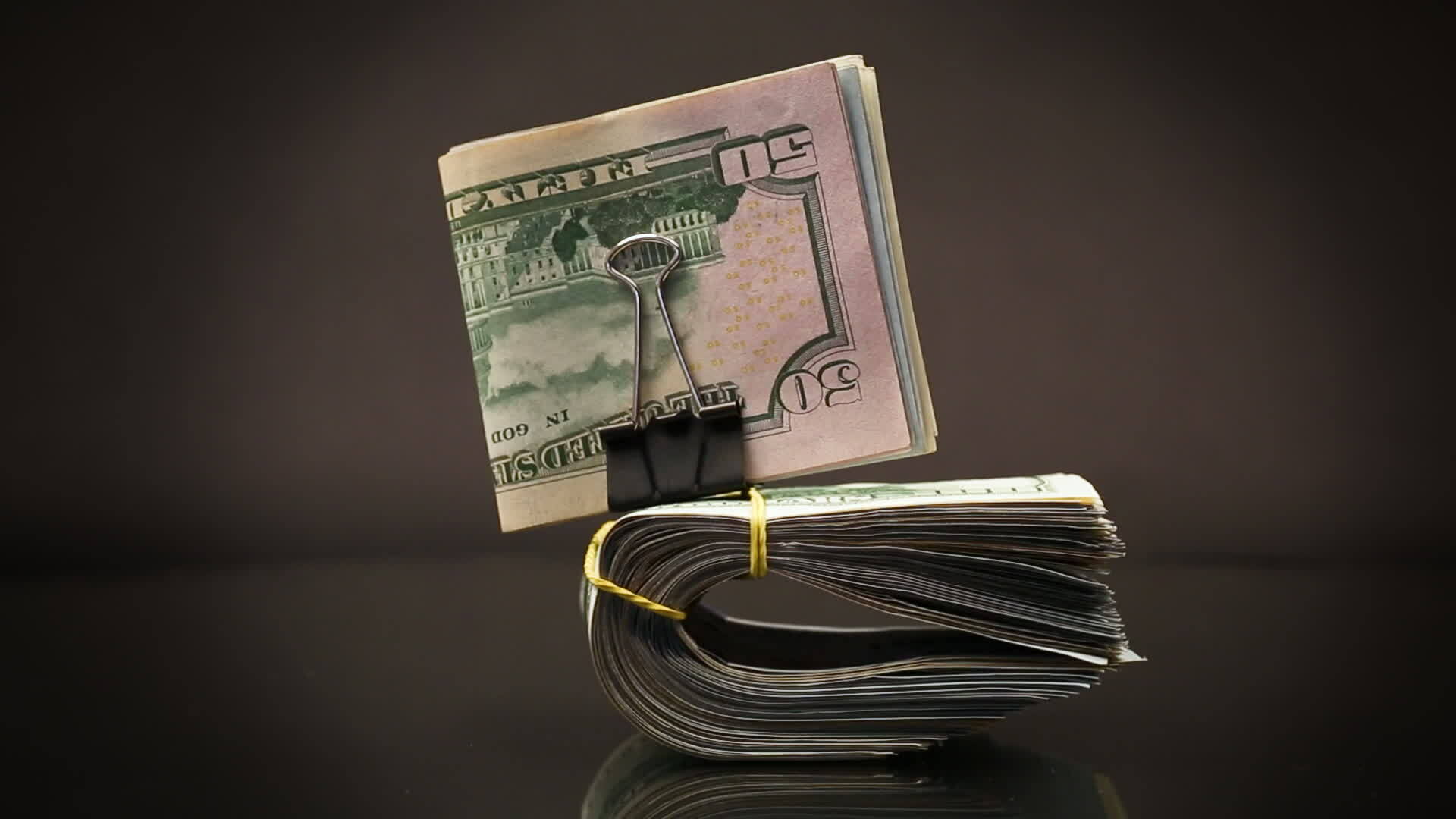 stack of dollar bills collected in an elastic band and a stationery