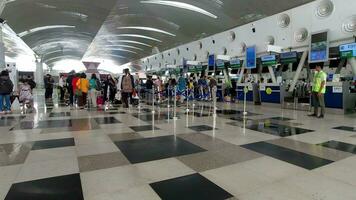 foule de touristes avec bagage dans le Kualanamu aéroport Terminal. Compagnie aérienne les passagers dans un international aéroport Terminal video