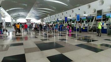 foule de touristes avec bagage dans le Kualanamu aéroport Terminal. Compagnie aérienne les passagers dans un international aéroport Terminal video