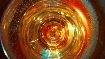 Looking inside glass of champagne, foam on surface disappears to reveal bottom. video