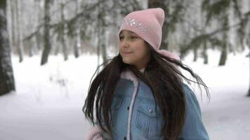 jovem lindo menina corre através a inverno floresta e sorrisos enquanto tendo uma Boa humor video