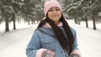 joven contento niña atleta carreras mediante el invierno bosque en un bueno estado animico y sonriente. 4k video