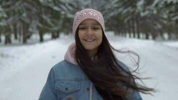 contento niña corriendo mediante el invierno bosque en un bueno estado animico y sonriente video