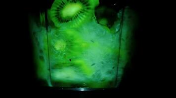 fresco kiwi fruta misturado dentro uma liquidificador em uma Preto fundo. video