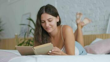 loisir à maison, rester dans le loger, magnifique femme, Accueil fin de semaine. attrayant femme mensonge sur lit dans chambre et en train de lire livre video