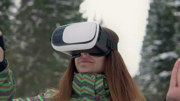 beautiful woman uses virtual reality glasses outside in the forest in winter video