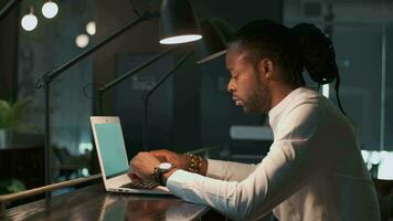 Creative business team, multiethnic group, coworking space. Creative african american businessman in shirt working in modern office using laptop video