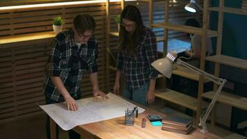 Two businessmen working on a drawing while standing over the table in the office video