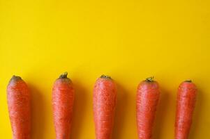 Natural organic carrot lies on yellow background. photo