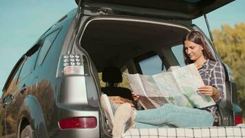 Finding strategy, Explore area, Find solution, Woman tourist. Woman traveler looking for a route using a paper map while sitting in a car video