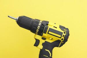 Yhe yellow-black screwdriver on a yellow background. photo