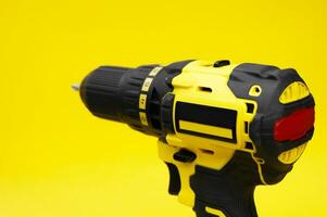 The yellow-black screwdriver on a yellow background. photo