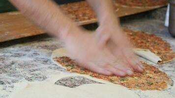 das Koch Hände bilden ein runden Pizza Base von das Teig mit seine Hände. video