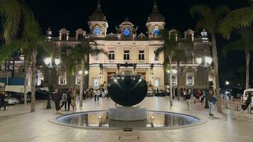 Mónaco, Monte Carlo, 12 noviembre 2022, casino a noche, el famoso cuadrado, atracción noche iluminación, lujo carros, jugadores, turistas, reflexión en piscina video