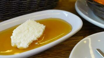 mantequilla crema y miel en un cuenco en mesa . video