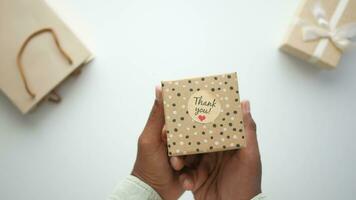 top view of holding a gift box with thank you sticker video