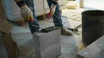 a builder applies concrete mortar to a brick video