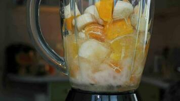 Fruta zalamero mezclado en licuadora, súper lento movimiento. naranja, banana, manzana en un licuadora. sano y vegetariano comida concepto video