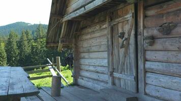 une voyageur feuilles un vieux en bois maison. le réel Accueil de Carpates bergers dans le montagnes. concept de aventure, Voyage et échapper de le ville. lent mouvement métrage 4k video