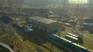 Aerial view of a small diesel locomotive maneuvers in a railway depot, 4K video