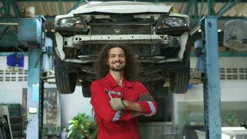 Young caucasian repairman analyzing and fixing broken car in car repair mechanic shop video