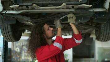 joven caucásico reparador analizando y fijación roto coche en coche reparar mecánico tienda video