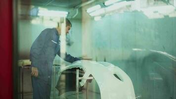 Caucasian man is cleaning car parts before spraying color in repair mechanic painting shop video