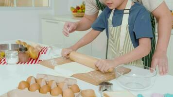 Happy Young Asian father and son cooking in kitchen at home video