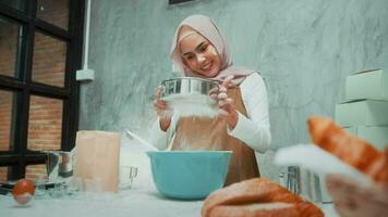 jovem e bela mulher muçulmana está assando em seu negócio de cozinha, padaria e cafeteria video