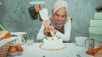 Young beautiful muslim woman is baking in her kitchen , bakery and coffee shop business video