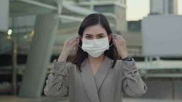 un' ritratto di donna d'affari è assunzione viso maschera via nel moderno città , persone stile di vita , fine di covid-19 pandemia concetto video