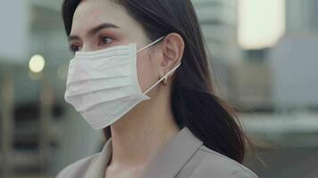 A portrait of Businesswoman is taking face mask off in modern City , people lifestyle , End of Covid-19 pandemic concept video