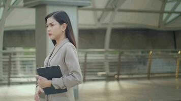 un joven hermosa mujer de negocios es caminando en moderno ciudad , ciudad estilo de vida concepto video