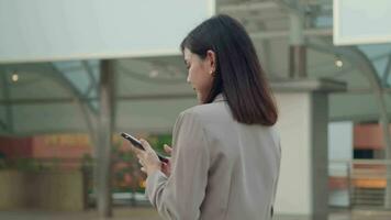 A young beautiful businesswoman is using Smart phone in Modern city , business technology , city lifestyle concept video