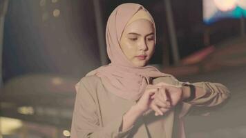 A young Muslim Businesswoman is using smart watch in modern City at night , Business technology lifestyle concept video