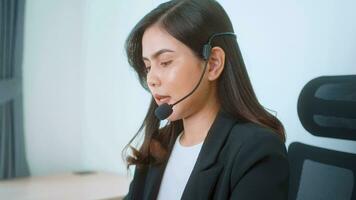 Female call center agent with headset consulting clients online, customer service and customer support operator concept video