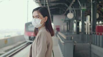 un' giovane donna è indossare protettivo maschera nel la metropolitana. piattaforma , covid-19 protezione , sicurezza mezzi di trasporto , viaggio sotto pandemia concetto . video