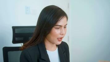 Young beautiful business woman working on laptop with documents in modern office video