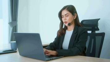 Female call center agent with headset consulting clients online, customer service and customer support operator concept video