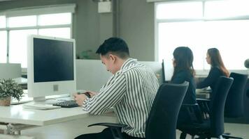 A business man is playing mobile games on his smartphone in office video