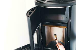 Man cleaning pellet stove with brush photo