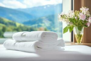 AI generated a stack of white towels on a bed in a hotel room, against the backdrop of a panoramic window overlooking green alpine meadows photo